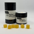 Higher Standard Pain Be Gone CBD, CBN, and THC gummies for pain relief with jar and pineapple-flavored cannabinoid gummies.